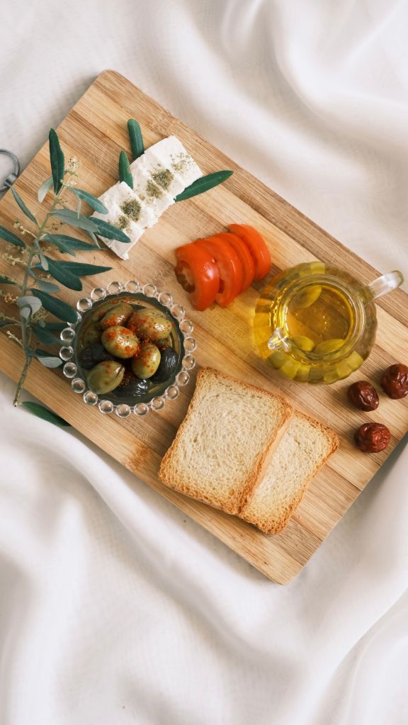 Mediterrane Zutaten von oben: Brot, Oliven und Olivenöl auf einem Tablett