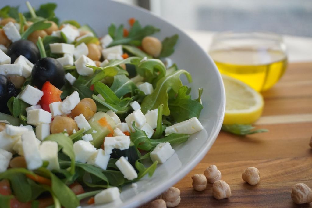 Bunter mediterraner Salat mit Kichererbsen, Oliven, Feta und frischem Grün